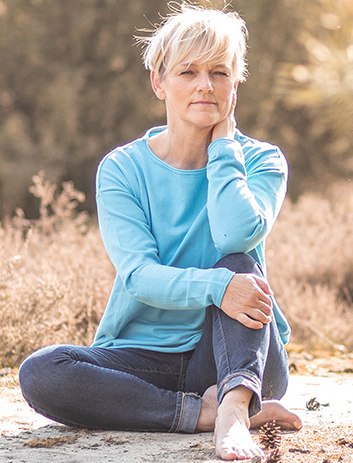 Angela Gutting sitzt entspannt in der Natur